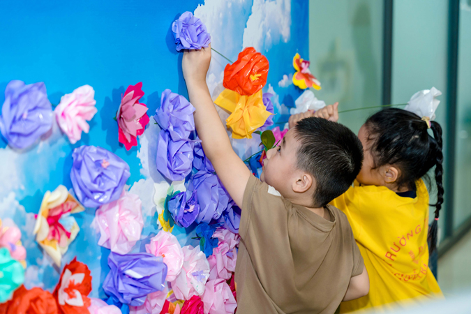 Trẻ em góp hoa tái chế lên bức tường hoa cộng đồng tại Merry Plaza Richmond City